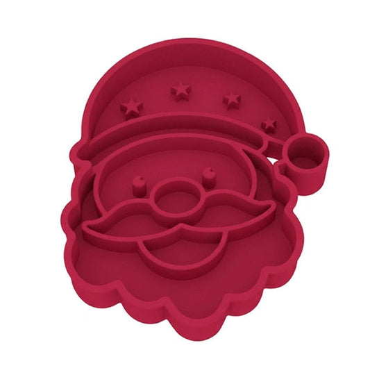 ​ Dog enjoying a meal from the festive Father Christmas slow feeder bowl under the Christmas tree, combining fun with portion control