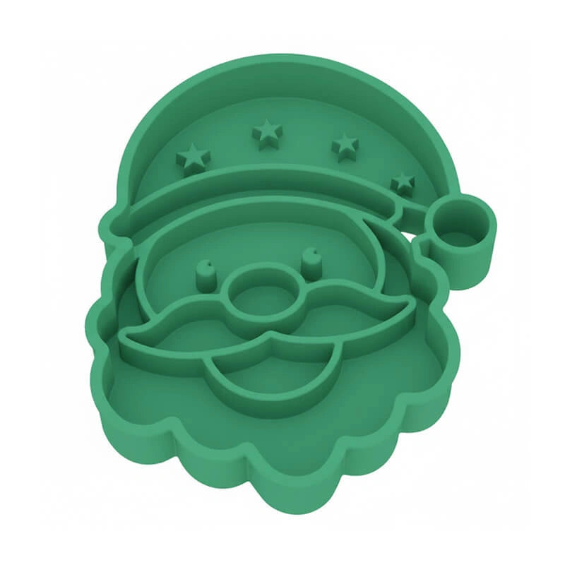 ​ Dog enjoying a meal from the festive Father Christmas slow feeder bowl under the Christmas tree, combining fun with portion control