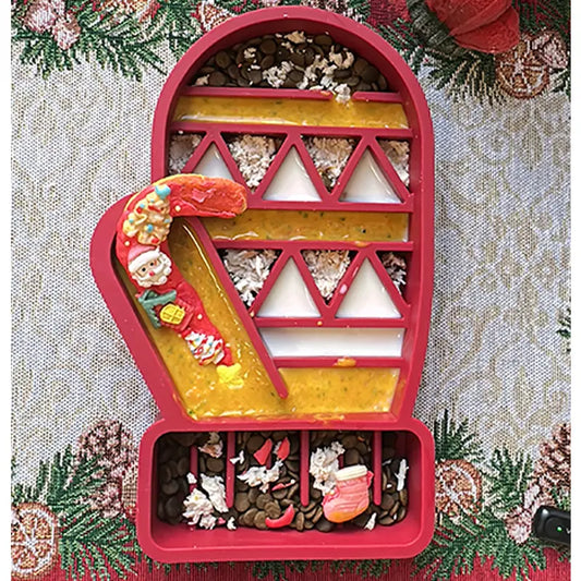Red two-sided Christmas glove slow feeder bowl for dogs, featuring easy-grip ridges on one side and detailed Santa, bell, and tree patterns on the reverse for multi-level slow feeding.​​